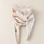 Foulard enfant beige à motifs d’animaux aviateurs, d’avions et de montgolfières, avec doublure blanche, présenté sur fond crème.