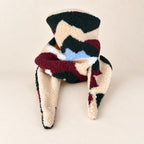Foulard enfant en tissu bouclé à formes vert forêt, bordeaux, crème et bleu clair, avec doublure beige, présenté sur fond crème.
