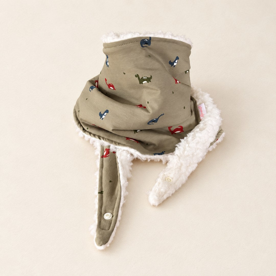 Foulard enfant kaki à motifs de petits dinosaures, avec doublure blanche et deux pans ouverts, présenté sur fond crème.