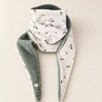 Foulard enfant écru à motifs de petits tracteurs et d’animaux de ferme, avec doublure vert sauge, présenté sur fond crème.