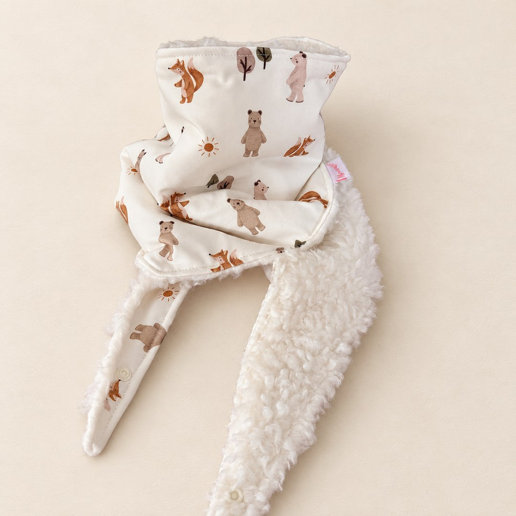 Foulard enfant écru à motifs d’ours, d’écureuils et d’arbres, avec doublure blanche et deux pans ouverts, présenté sur fond crème.