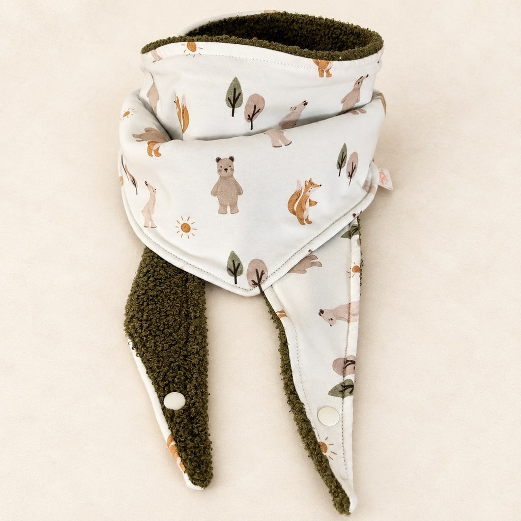 Foulard enfant écru à motifs d’ours, d’écureuils et d’arbres, avec doublure kaki et deux pans ouverts, présenté sur fond crème.