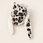 Foulard enfant écru à motif léopard noir et mauve, avec doublure blanche et deux pans ouverts, présenté sur fond crème.