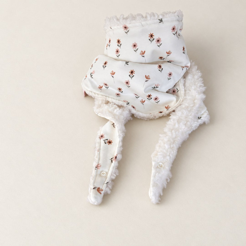 Foulard enfant écru à petites fleurs roses et camel, avec doublure camel et deux pans ouverts, présenté sur fond crème.