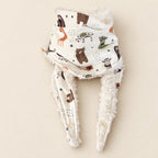 Foulard enfant écru à motifs d’animaux de la savane stylisés, avec doublure blanche et deux pans ouverts, présenté sur fond crème.