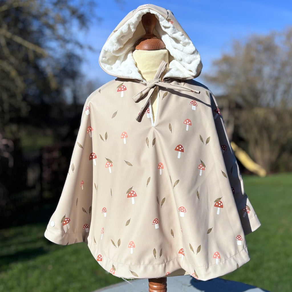 Poncho de pluie bébé/enfant beige à capuche, imprimé champignons, doublure en tissu minky blanc.