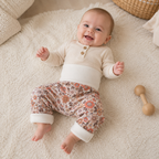 bébé sur un tapis portant un sarouel évolutif avec fleurs vintage
