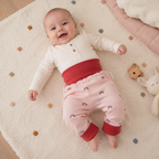 bébé portant un sarouel évolutif saumon avec des motifs arc-en-ciel