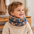 Enfant portant un snood à motifs renards sur fond bleu avec intérieur doux beige
