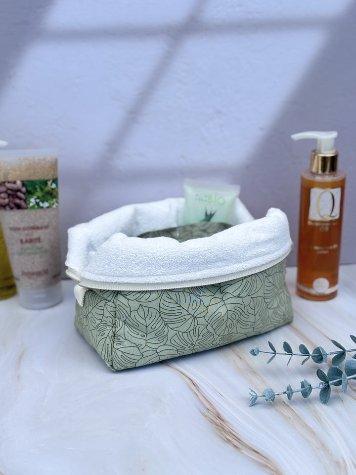 trousse de toilette cubique ouverte sur une tablette de salle de bain